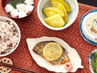 レモンを添えた焼き魚と赤飯とたくわん