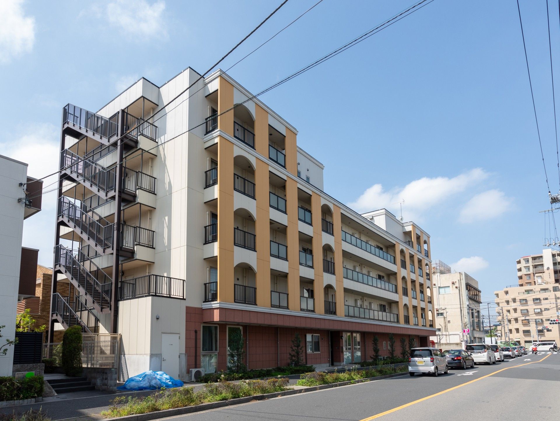 オレンジと赤、白の建物は高齢者向けの施設のように見えないポップなデザイン。街中にあり、道路に面している。