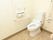 トイレの壁には、L字型に手すりを設置しており、立ち座りの際に体を支えることができる。温水洗浄便座が採用されている。