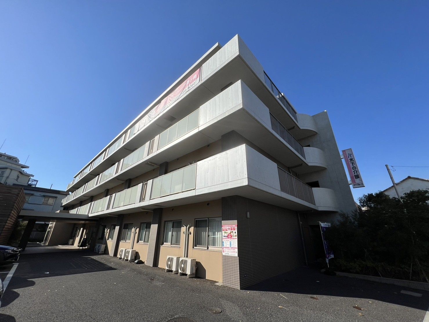 車椅子に乗った高齢女性の後ろで微笑むヘルパー