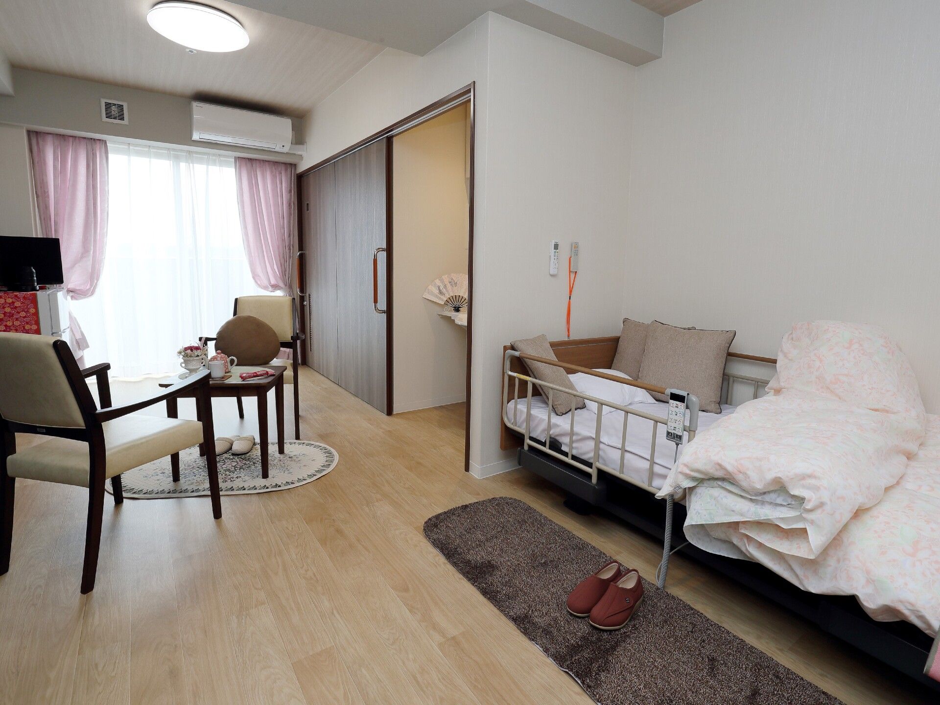 白を基調とした明るい居室にはベッドや収納、エアコンなどの家具家電がそろっている。