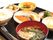茶色いお盆の上にお味噌汁、焼き魚、ご飯、漬物などが載っている。