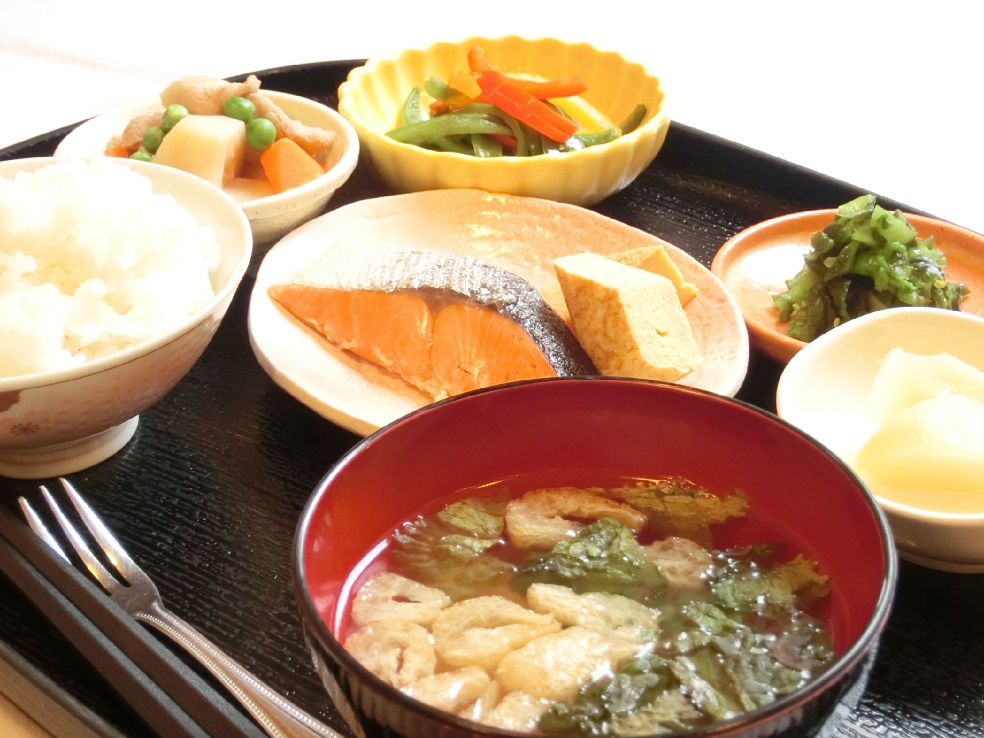 お盆の上にご飯とお味噌汁、焼鮭、副菜が載っている。