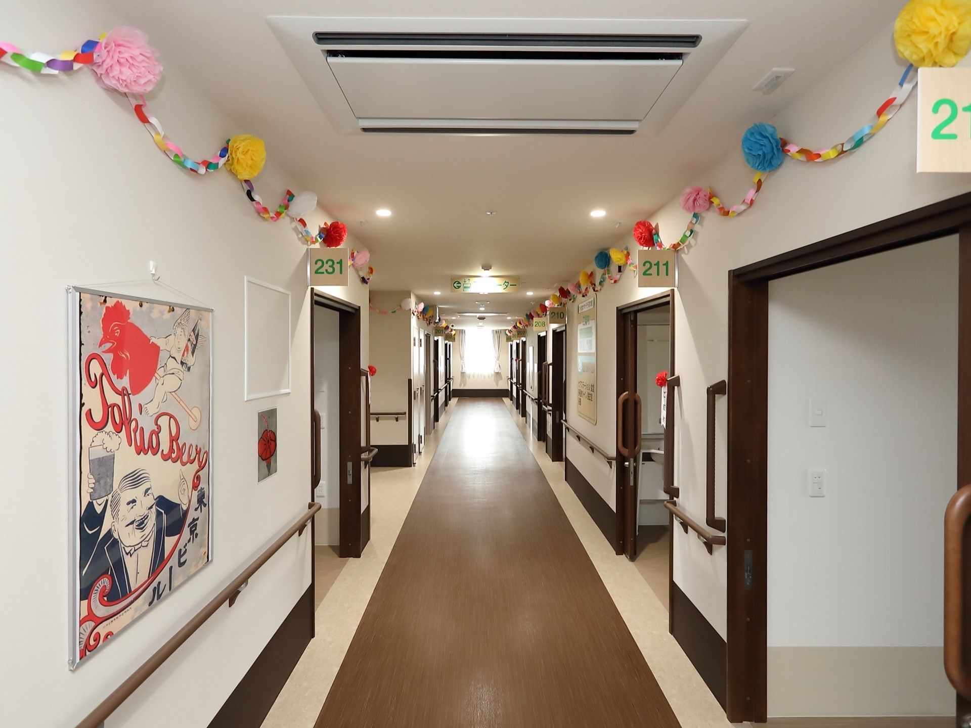 通路の床は全面フラットで、幅はゆったりとした広さがある。壁には手作りの紙細工や絵を飾り、各所に手すりを取りつけている。
