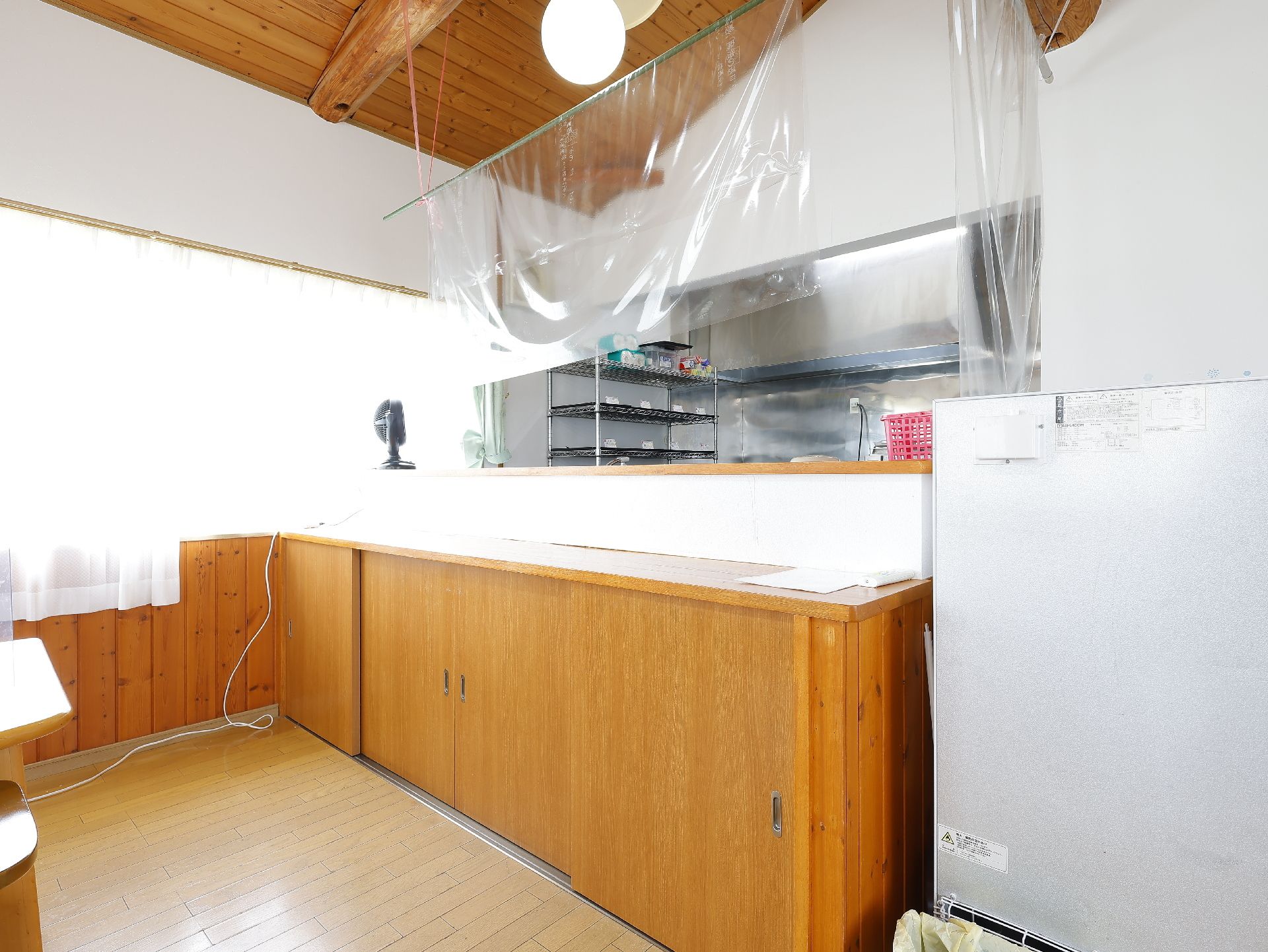 高齢者2名とスタッフが手を握りながら談笑している様子。施設内の会話の一画面