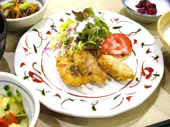 洋食のメニューを写した写真。少量の揚げ物とサラダが載った皿