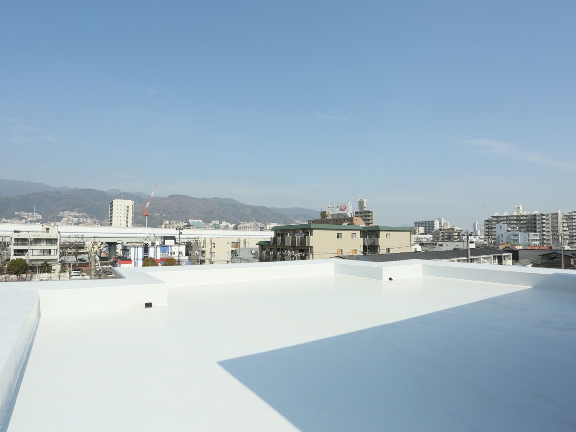 施設の屋上の様子である。白色で統一され、日差しが当たるととても明るい。周りの景色が一望でき、気持ちよく外の風を感じられる。