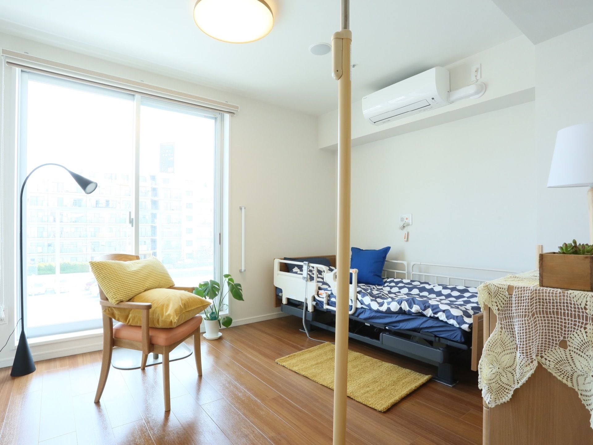 居室は大きな窓があり、外の景色が一望できる造りとなっている。中にはベッドやクッションの置かれた椅子、独特なデザインの照明などがある。