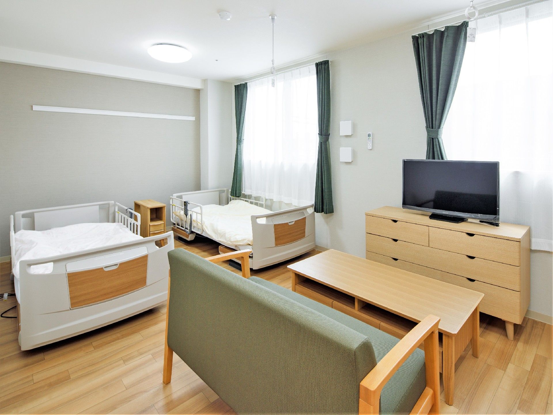 ひとりで部屋でくつろいでいる男性。ホワイトを基調とした部屋で明るい様子が分かる