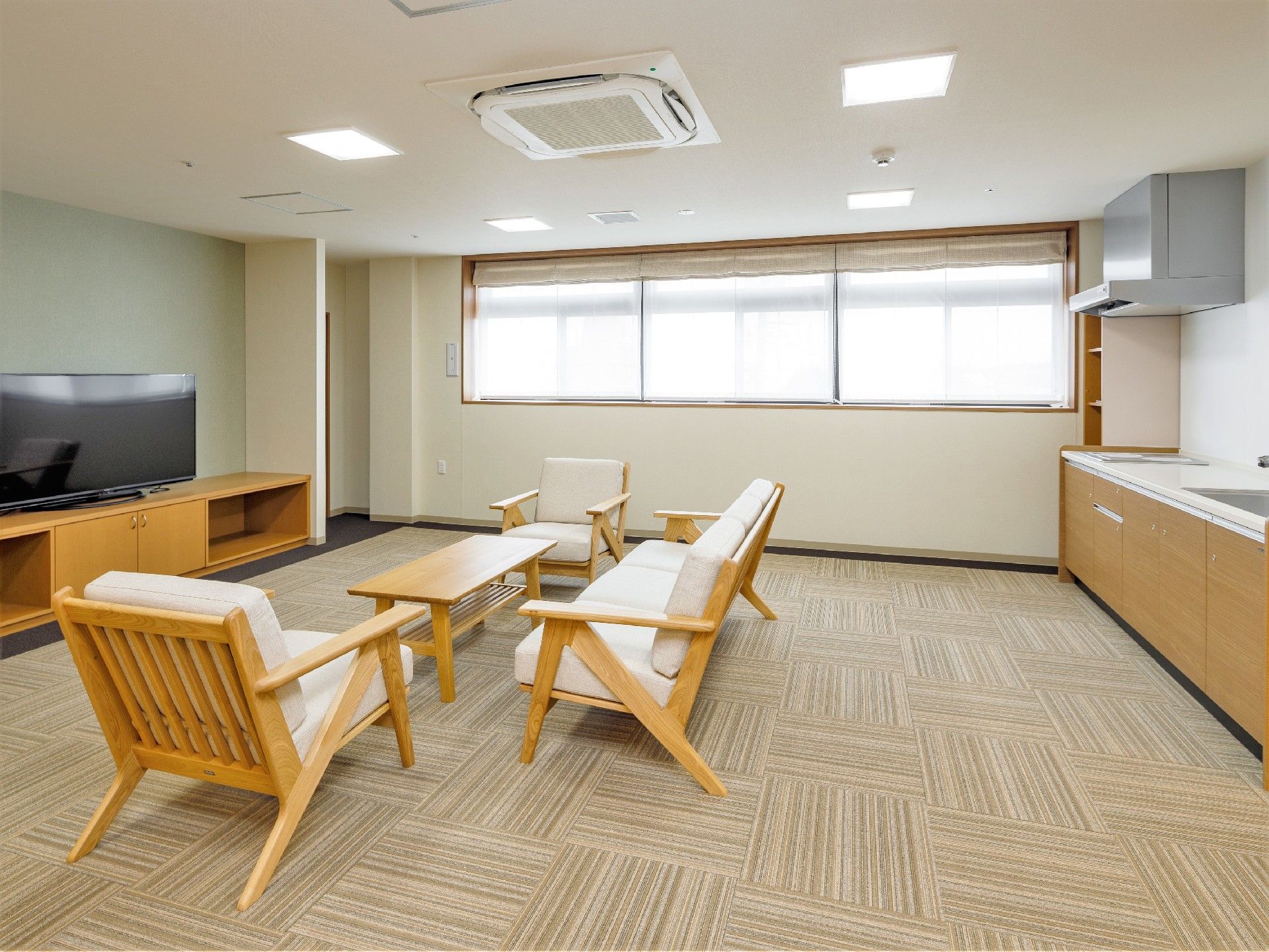 カウチソファとテーブル、テレビなどがゆとりを持っておいてあるリビングスペース。みんながくつろげる広めの部屋