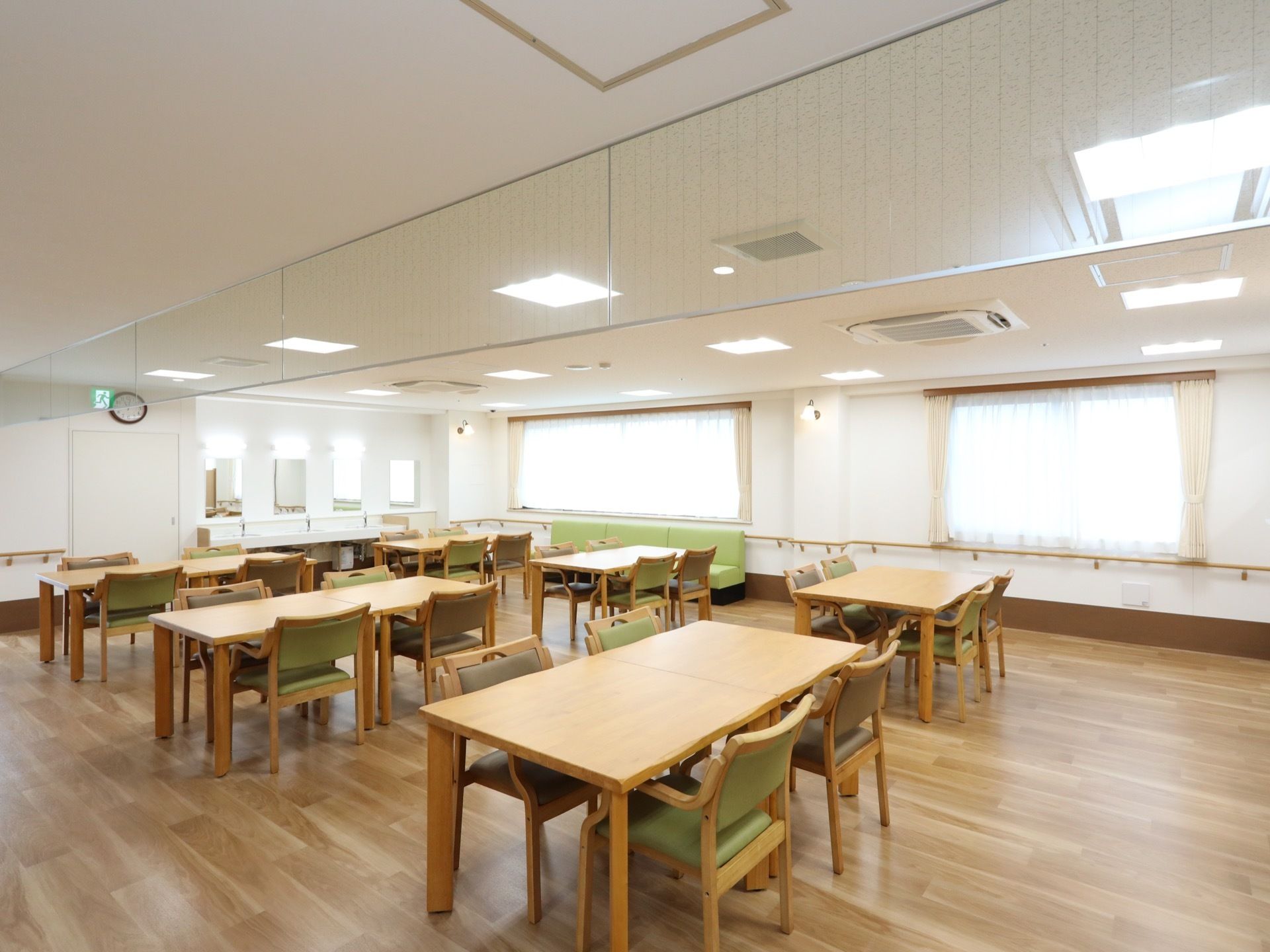 食堂としても共有のリビングとしても使える部屋。窓側にロングタイプのソファが置かれ、壁には手すりが設置してある。
