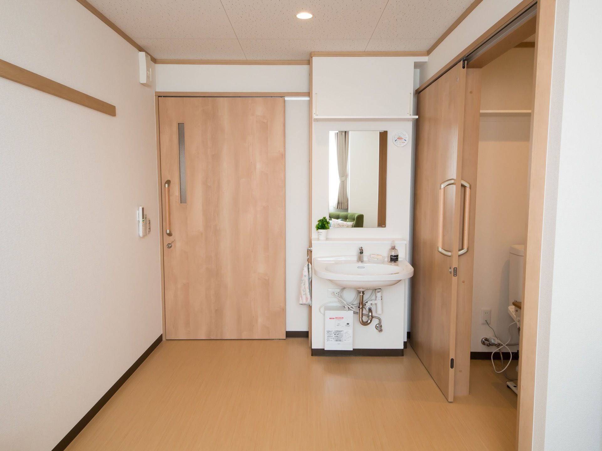 居室は玄関の横に洗面台、その向こう側にはトイレが配置されたレイアウトとなっている。スイッチ類はドアの脇にある。