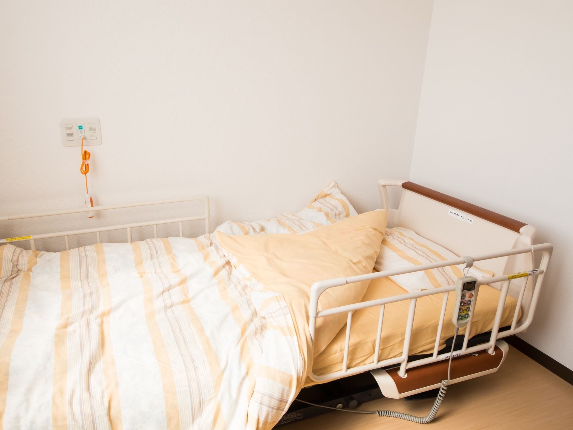 居室にあるベッドは、介護用にリクライニングやリフト機能が付いたものとなっている。コントローラーは転落防止フェンスに掛けてある。