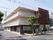 通りに面した施設の外観。白みがかった外壁と、階段そばの赤茶けた外壁がある。