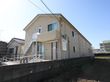 奥行きのある２階建ての施設である。玄関に向かって右隣の敷地は、広い空き地になっている。白いフェンスで囲まれている。