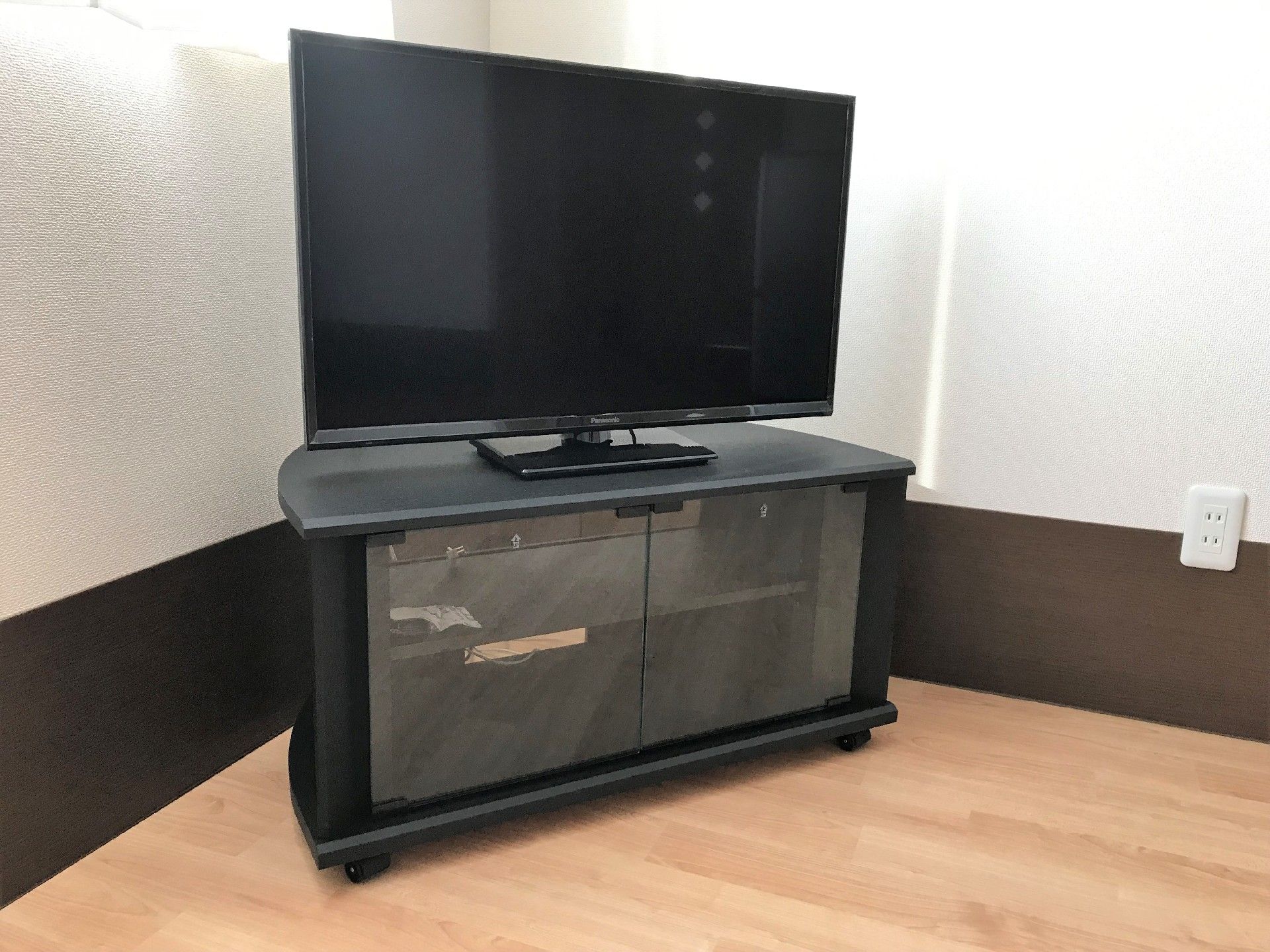 大型の薄型テレビがテレビラックの上に。コーナーの角にテレビが置かれ、よく片付けられている。