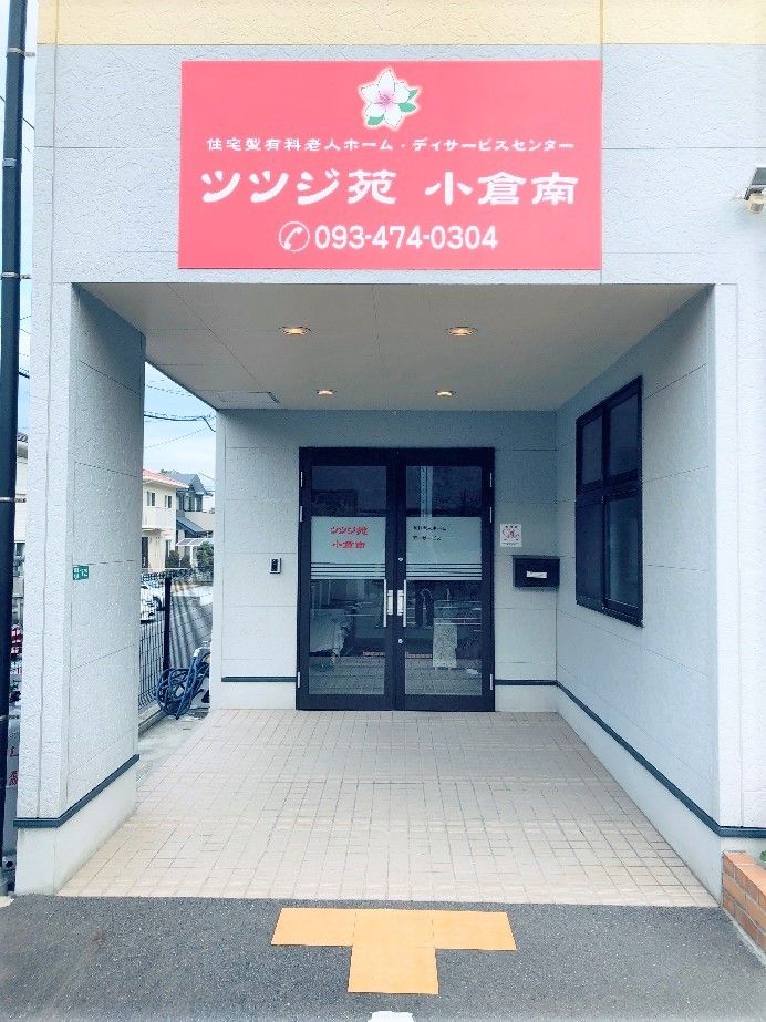 建物の玄関は少し中に入っていて屋根が付いた形となっている。玄関先には赤い看板が掲げられている。