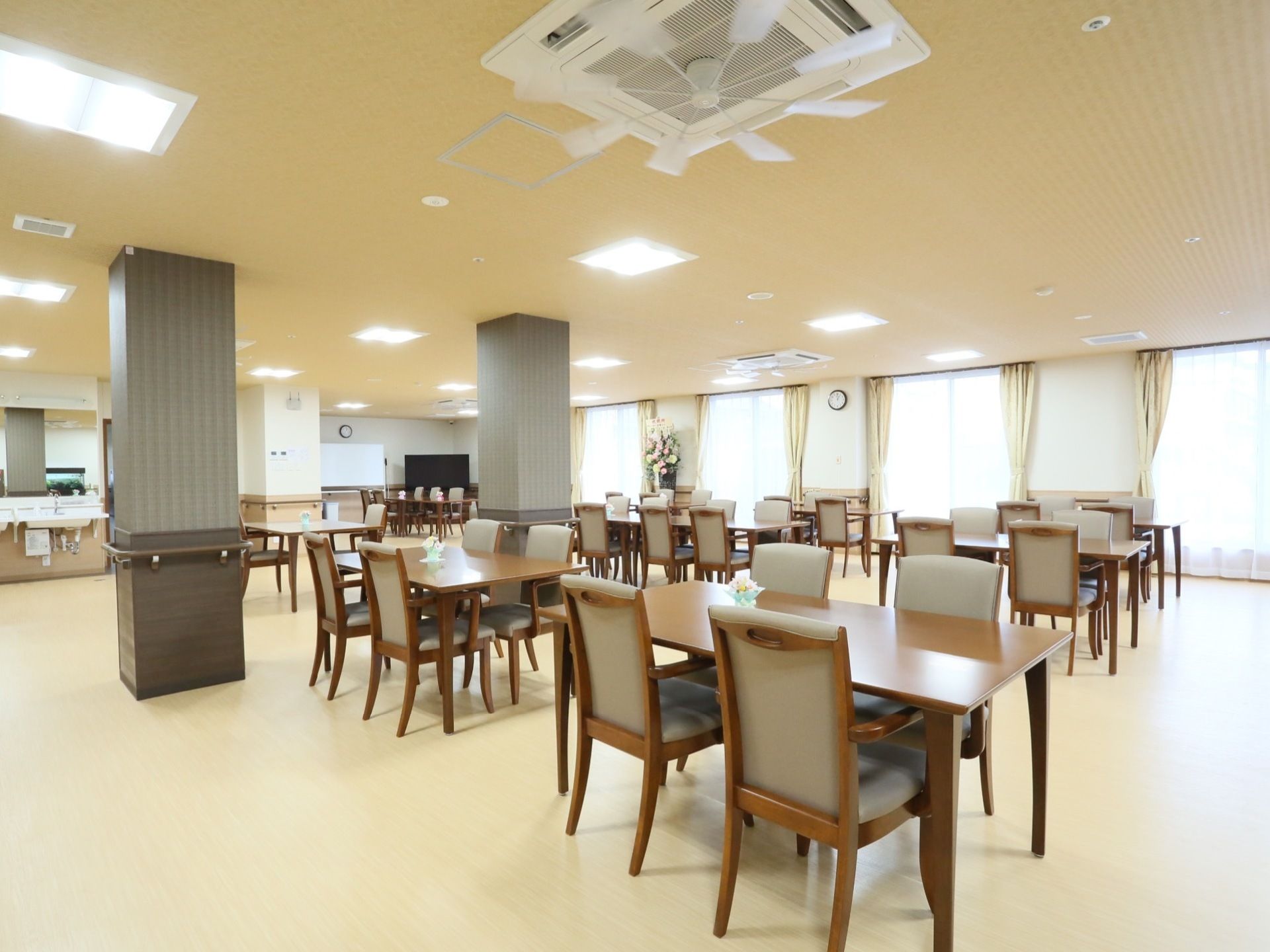 ４人掛けのテーブルが等間隔にたくさん並べられており、それぞれ肘掛け椅子が４脚ずつ用意されている。すみには、洗面台がある。