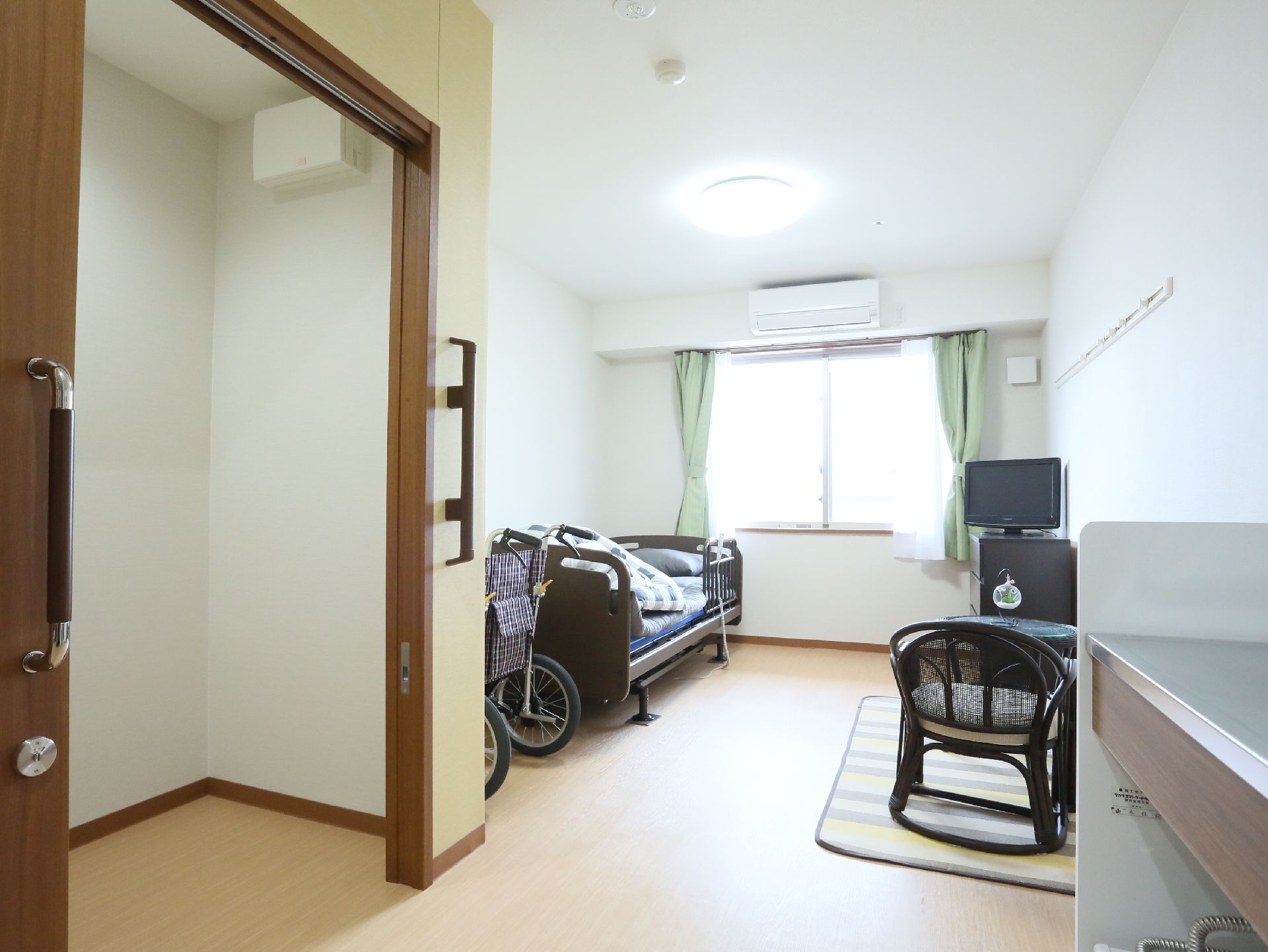 居室にはエアコンやベッドなどの家具家電が置かれ、キッチンもついている。