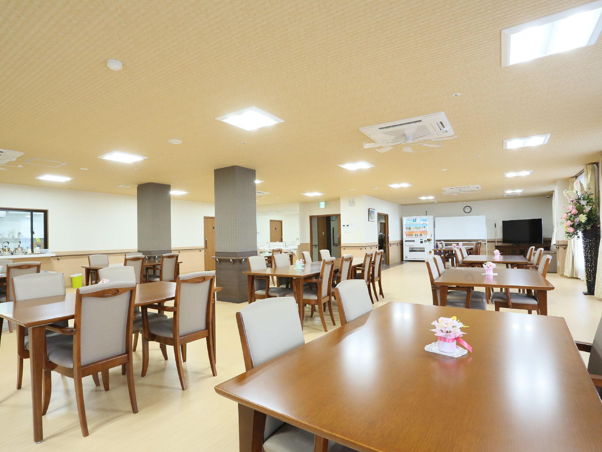 食堂には木製のダイニングテーブルが並び、入居者は食事の時間以外にも使用できる。