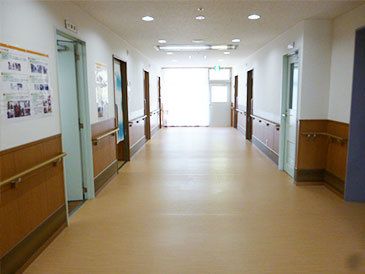 廊下部分を写した写真。手すりが取り付けられていて両側に個室のドアがある