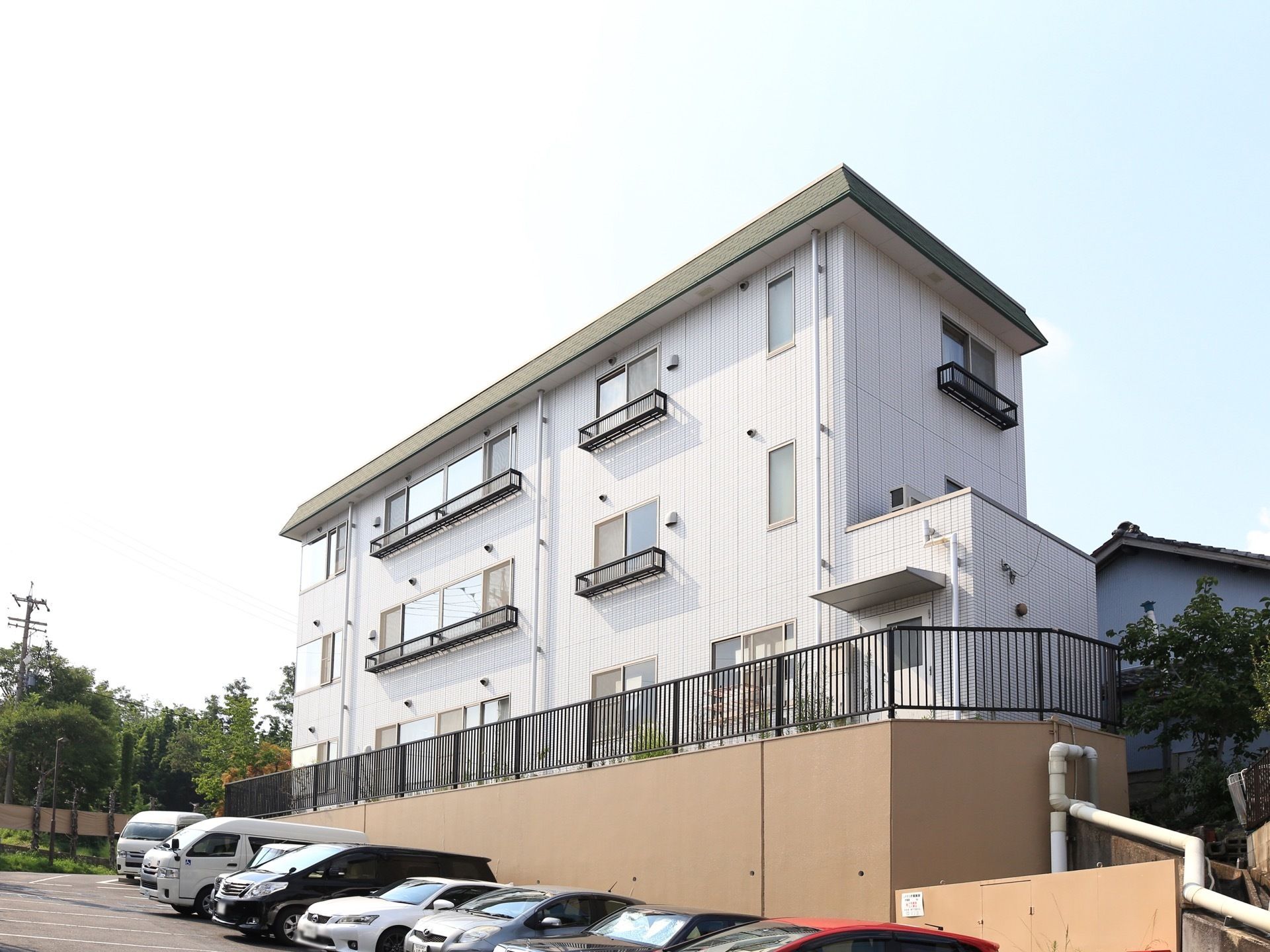 コンクリートで高台の上に、白い3階建ての施設が建てられている。周囲は見晴らしが良く、日当たりも良い。