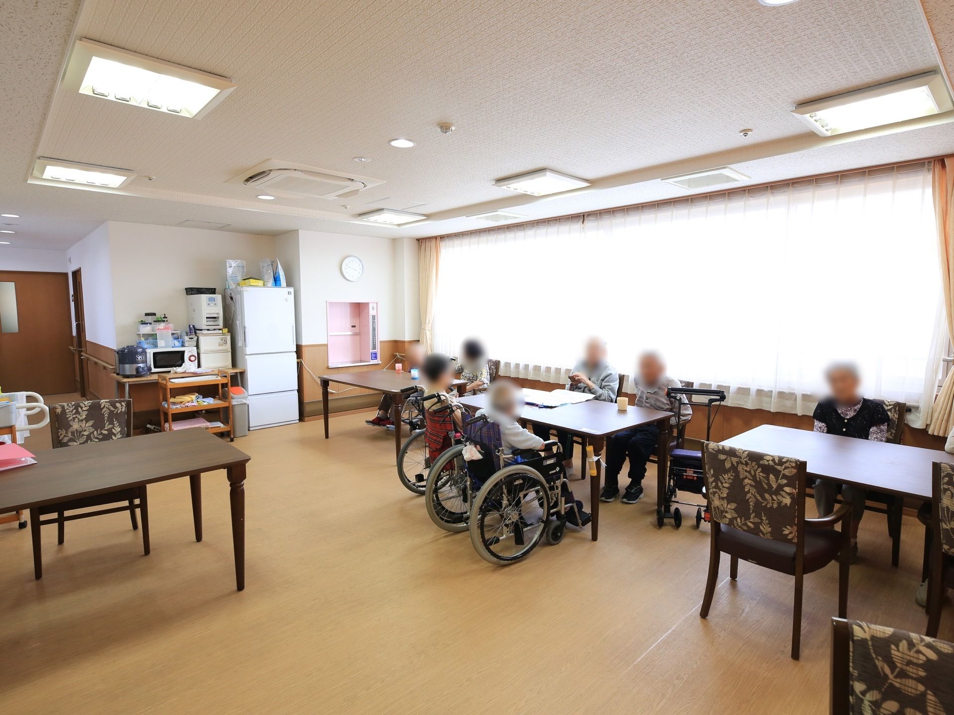 明るく居心地の良い窓際に、ダイニングテーブルが並べられている。テーブルの間は距離を空け、通路を広々と設けている。