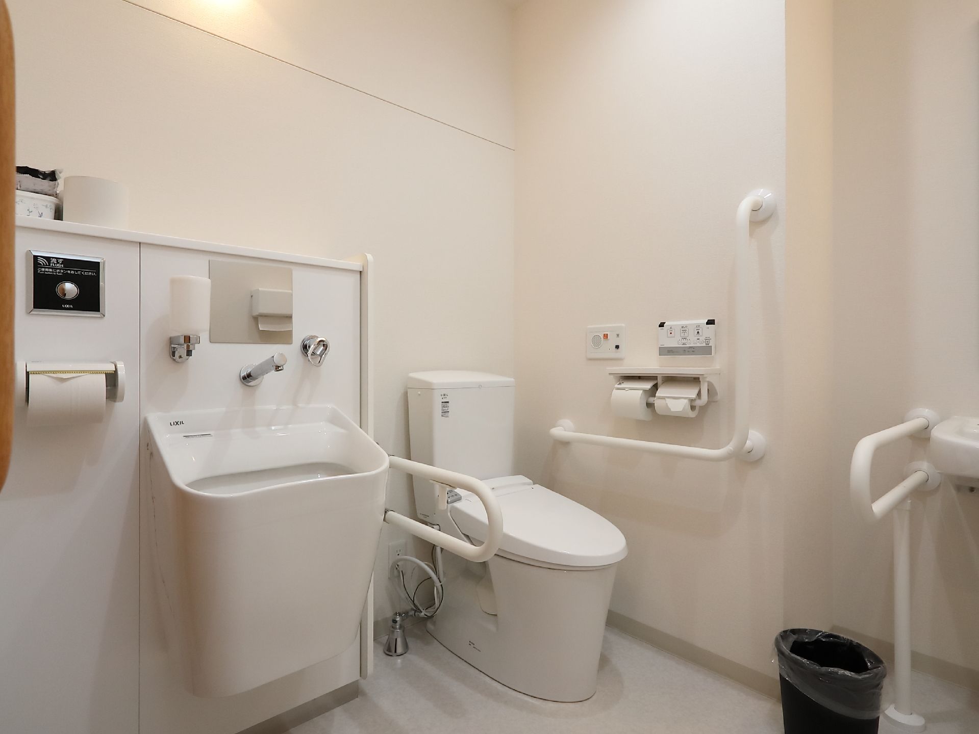 白を基調とした清潔感あふれる共用トイレで、オスメイト対応の設備も整っている。随所に手すりが取りつけられている。