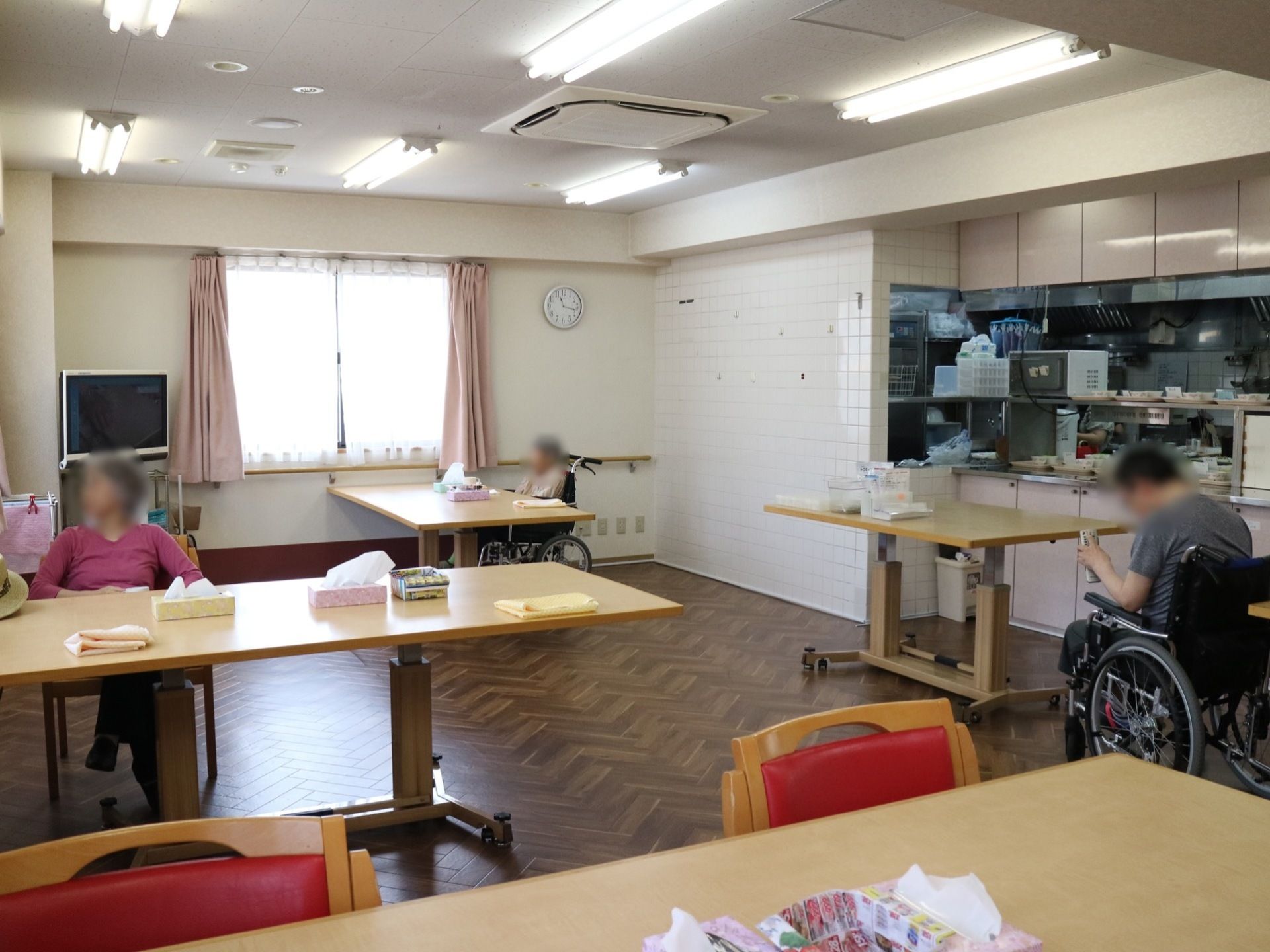食堂の床は、くの字にカーブした素材が組み合わさったデザインを採用している。壁側の窓の前に木製の手すりが設置してある。