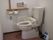 トイレには、温水洗浄式の便座が設置してあり、操作するボタンは壁に付いている。手を添えることができる棒も用意されいる。