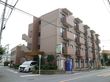 建物の周り、３面は道路に面している。２階以上の屋外には、１室ごとのベランダが見えている。外部には、外階段が設けられている。