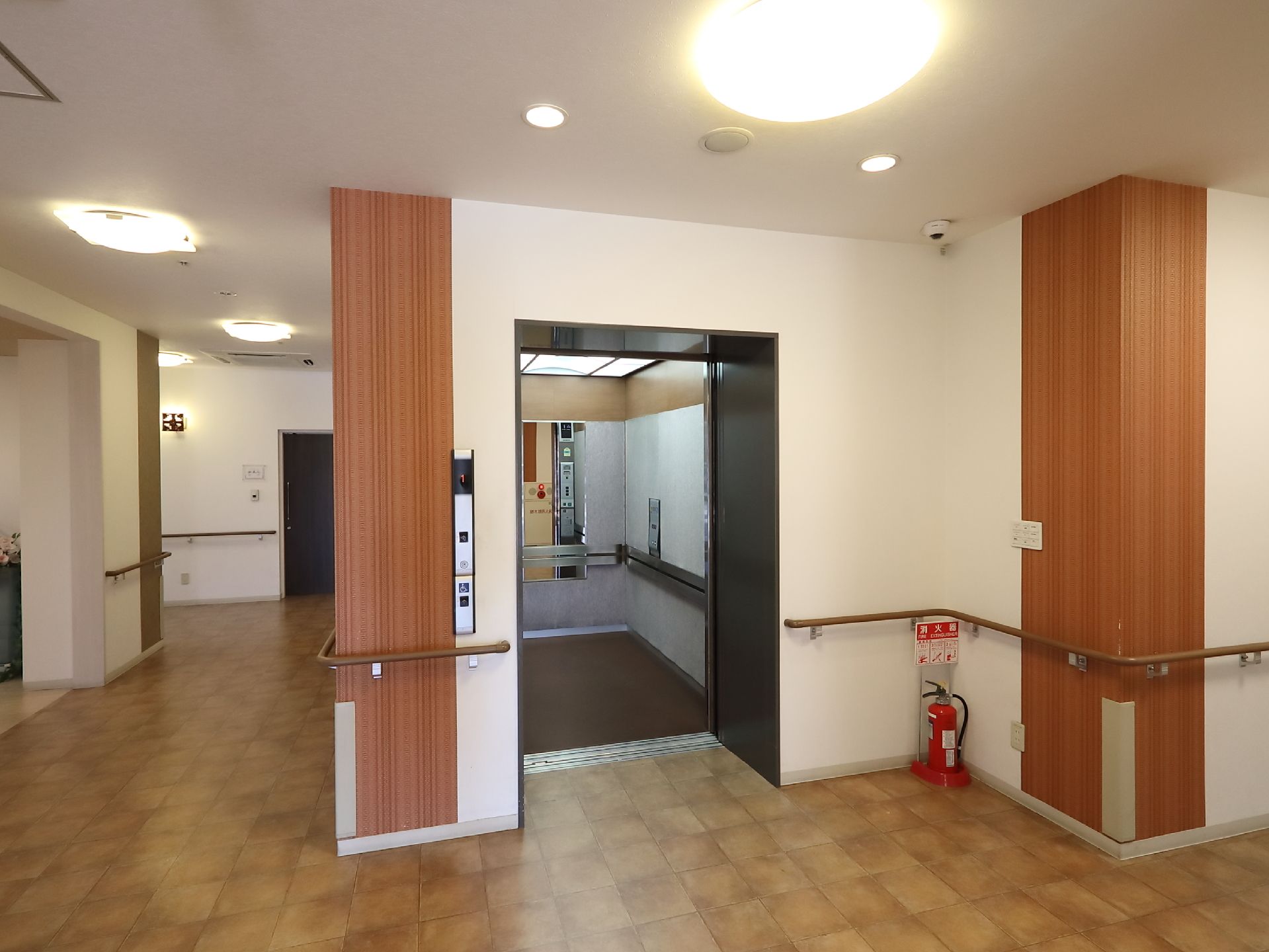 エレベーター内は広いので、同時に複数の入居者様がご利用になれる。移動中もお身体を支えていただけるよう、手すりを取りつけている。