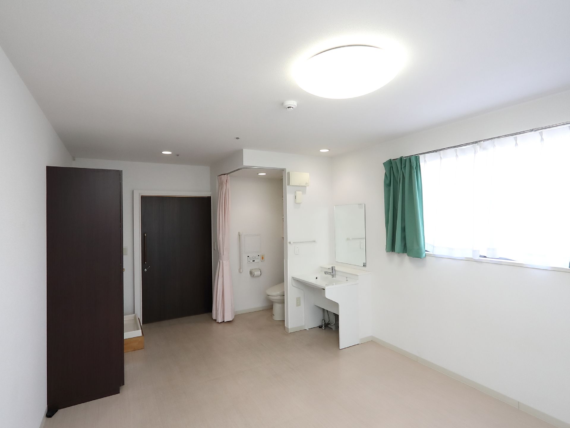 大きな部屋の片隅にトイレが設置されている。カーテンで仕切ることができ、プライバシーがきちんと守られている。