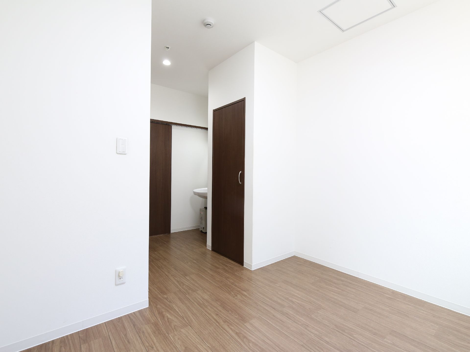 洗面台が備わっている、白い壁で清潔感のある居住スペース