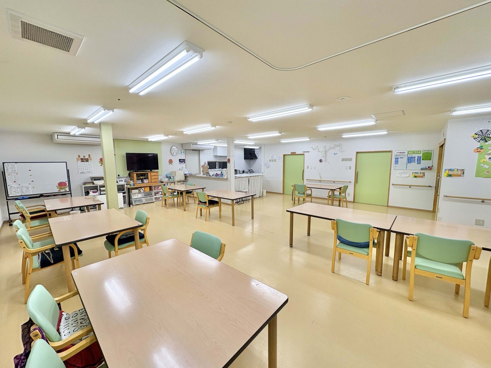 ベージュの椅子がセットされたダイニングテーブルセットが置かれた食堂にはカーテンのない窓が付いている。