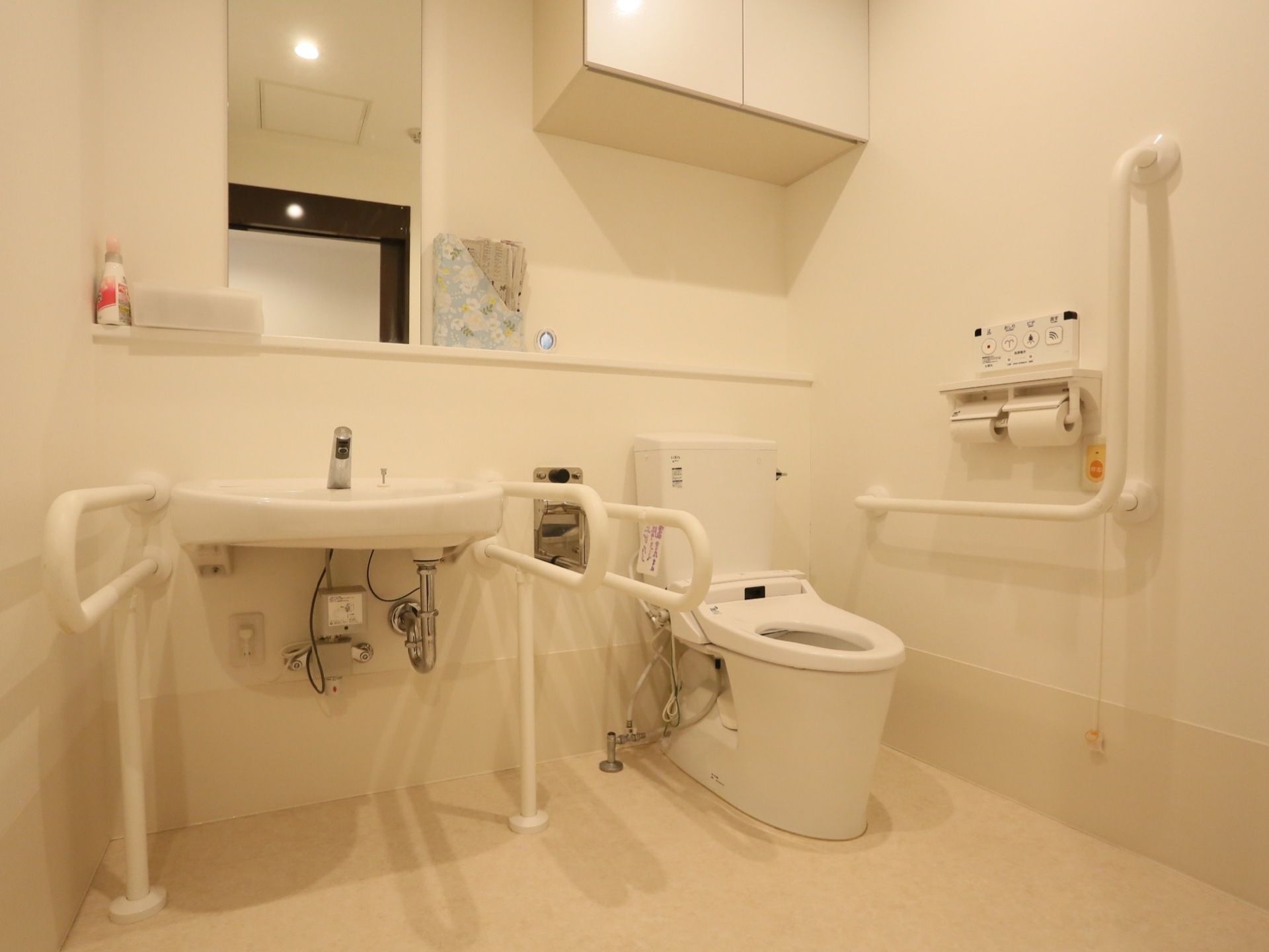 洗浄便座付きのトイレが設置されており、壁には手すりや緊急呼び出しボタンが備えつけられている。収納棚が設けられている。