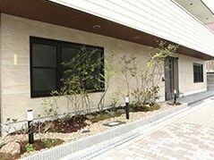 エントランスのそばには草木が植えられたスペースがあり、外灯も複数設置されている。