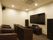 大きなテレビが設置された部屋には黒い一人用の椅子が設置されているシアタールーム。本格的な音響設備が整っている。