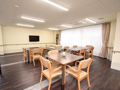 落ち着いた雰囲気のダークブラウンをメインにした共有スペースにはテーブルセットやテレビ、ソファなどがある。