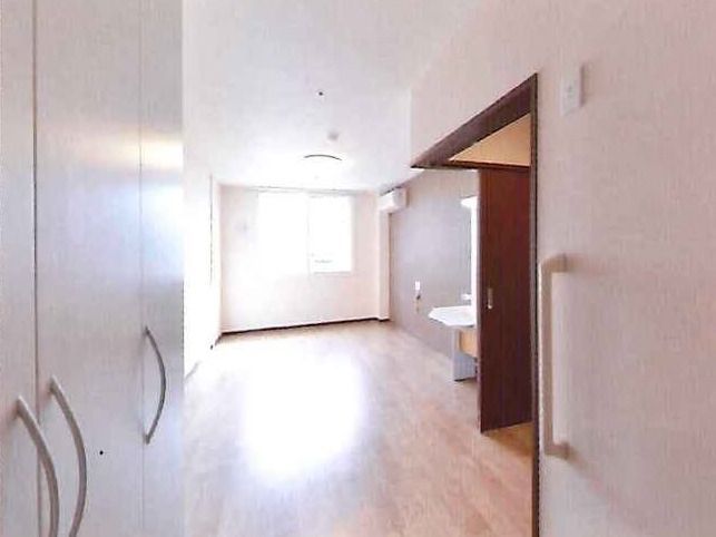 ワンルームタイプの小さな部屋の様子。エアコン、緊急コール、トイレや収納スペースがある部屋