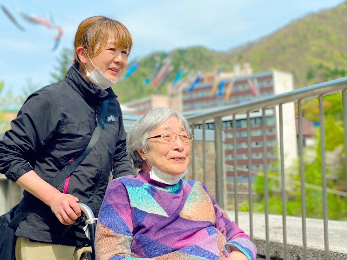 笑顔の女性と介助者の風景
