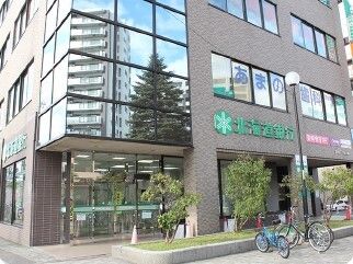 グレーの外壁の大きな建物の１階部分には緑の文字で「北海道銀行」と書かれている。