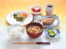 白いご飯や具だくさんのみそ汁、魚の干物に漬物、イチゴ、お茶などが並べられている。
