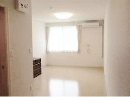 エアコンが付いた広い部屋には段差はなく、レースカーテンとカーテンが付いた大きな窓があり、明るい雰囲気。
