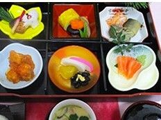 6つに仕切られた黒い弁当箱の中には小さな豆皿が置かれ、それぞれに異なる料理がきれいに盛り付けられている。