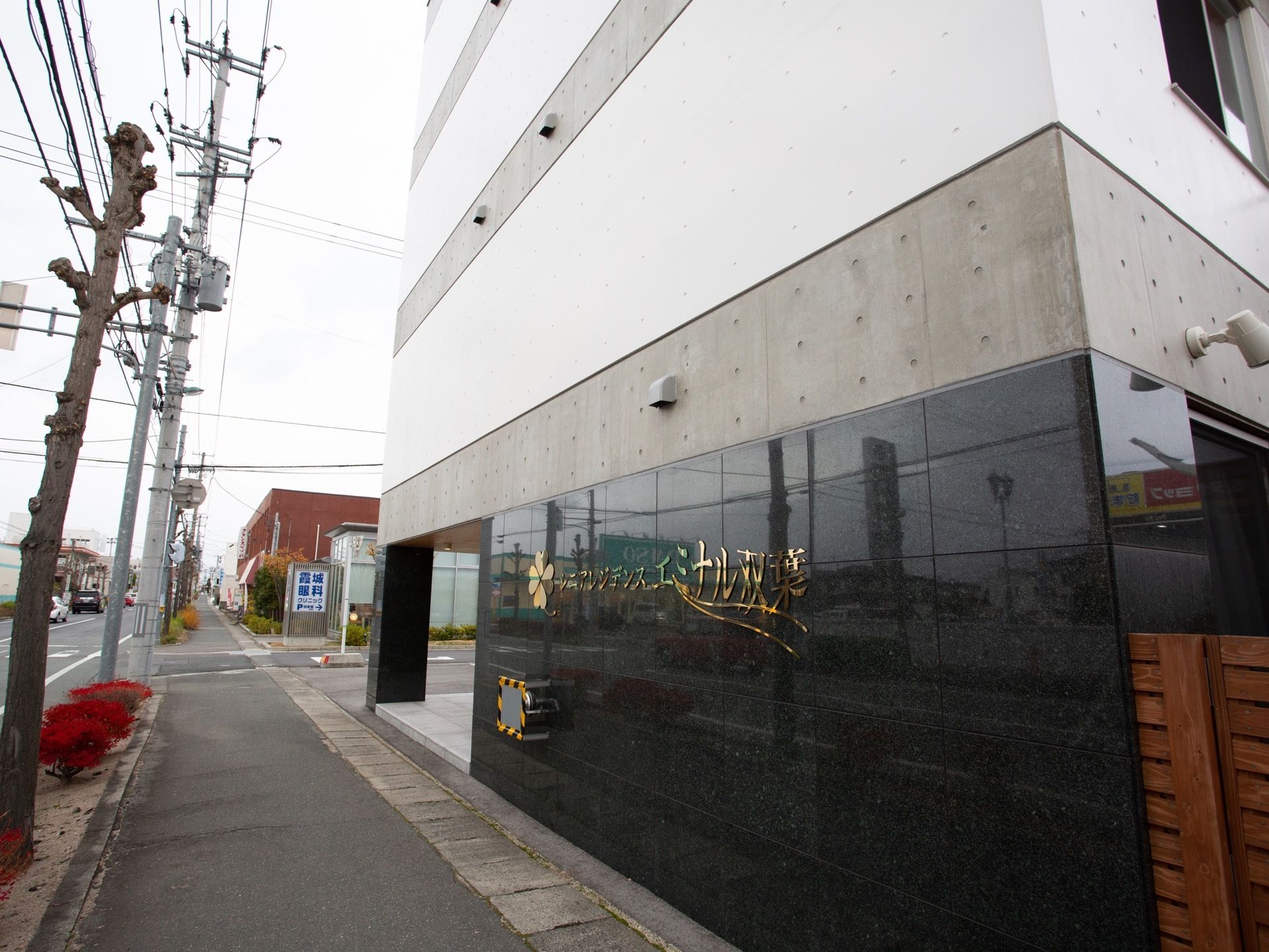 住宅街に位置しており、デザイナーズマンション風の施設外観である。外壁にはゴールドカラーで施設名が記されている。