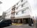 4階建ての施設。1階外壁は大理石のような質感。2階以上はコンクリートと白い壁が組み合わさっている。非常用階段が設けられている。