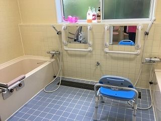 両サイドの一人用の浴槽が設置された浴室の中央にはシャワーや鏡、手すりが付いている。