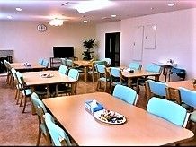 四角いテーブルと椅子がある施設のリビングスペース。食事をとる場所