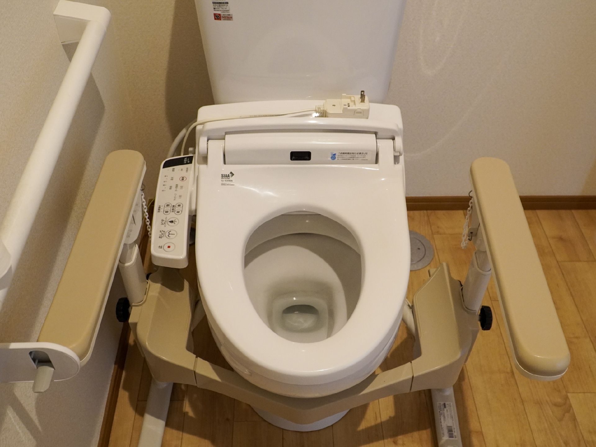 木製の手すりが付いた蓋がない洋式便器